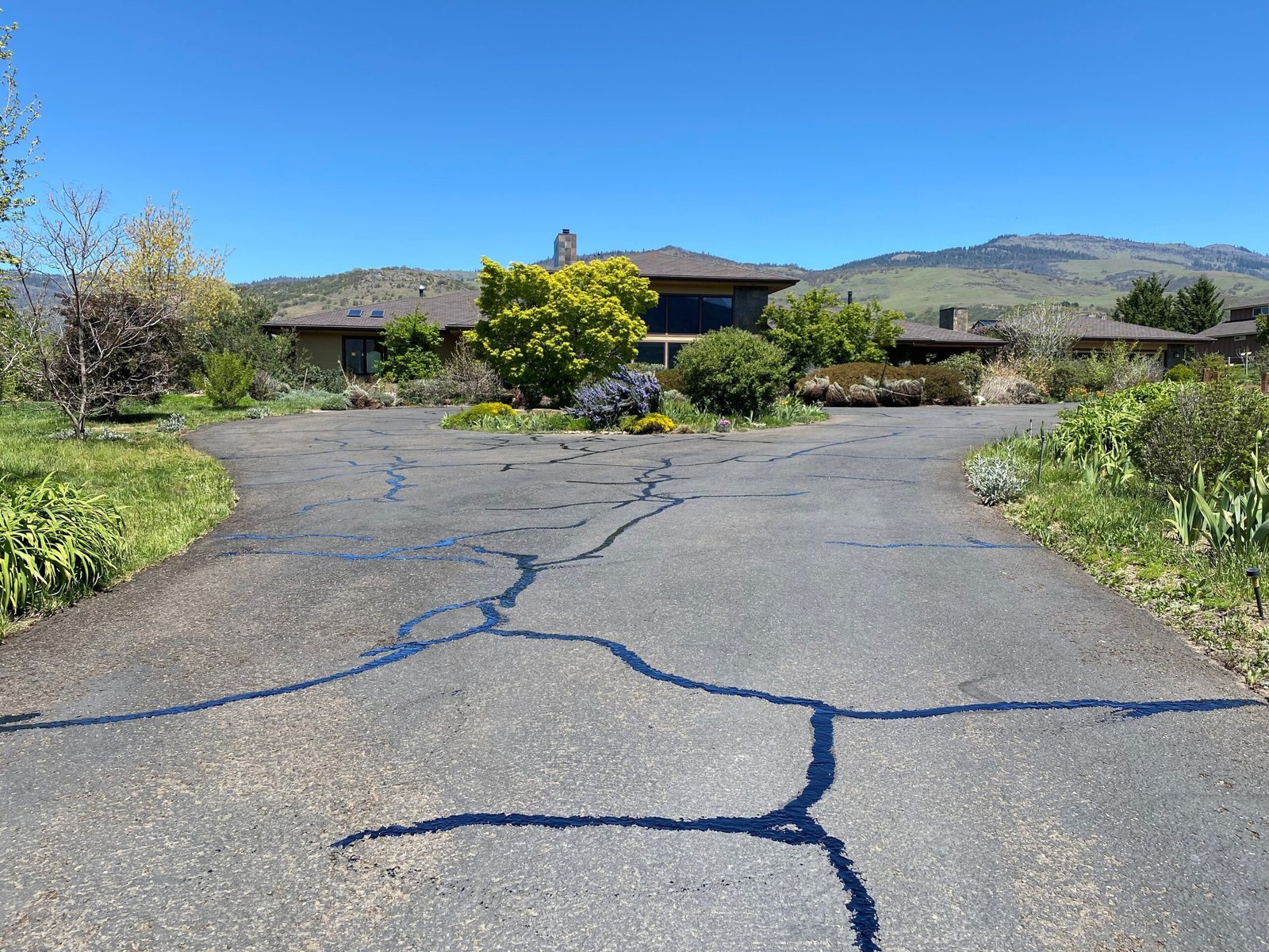 Hot crack sealing lines on an asphalt driveway by Musser Sealcoat and Paving Inc.